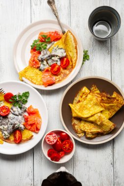 Kedi beyaz masada krep izliyor.