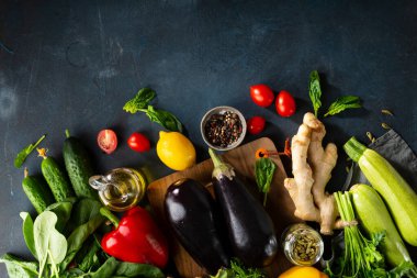 Koyu mavi arka planda farklı meyve ve bitkiler. Vejetaryen malzemeleri