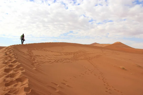 Turista escalando uma duna no deserto de Sossusvlei, Namíbia — Fotografia de Stock