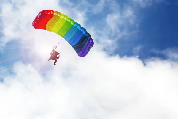 Gökkuşağı renginde paraşütle atlayan paraşütçü ağlar. — Stok fotoğraf
