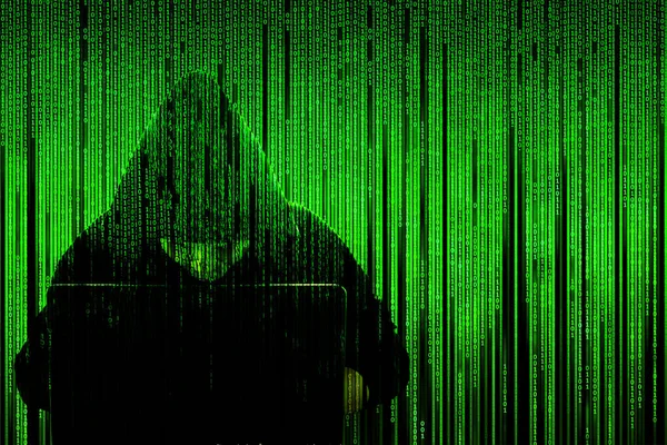 Silueta oscura de un hacker en una capucha con un portátil en un fondo de una matriz de código informático binario. Concepto: hacker y virus informático, robo de bases de datos, spam. Ilustración aislada en negro . —  Fotos de Stock