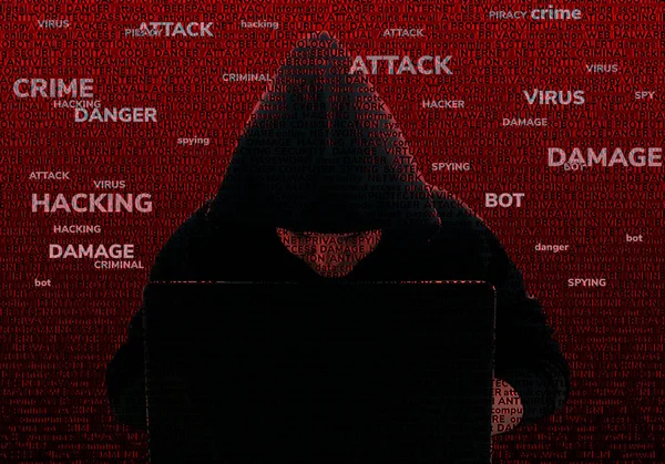 Un hacker anónimo en el capó con un portátil, contra la espalda —  Fotos de Stock