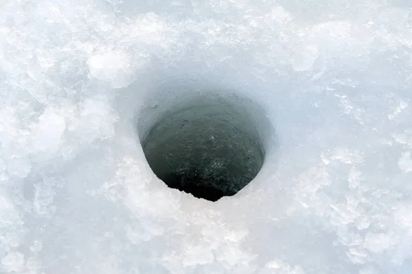 Winter fishing. Hole in the ice for fishing. Hole in the ice, close-up.