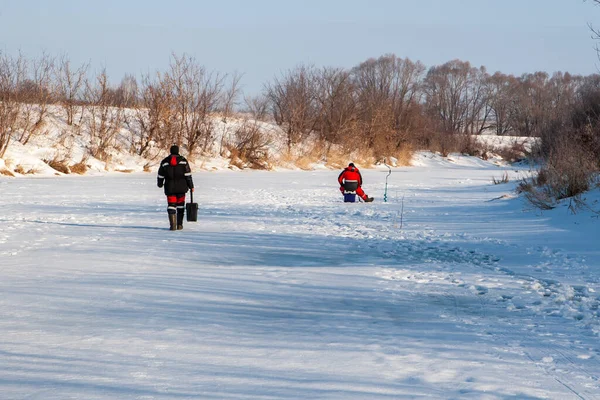 Ice fishing. Winter fishing. Fishermen on the ice of the river are engaged in ice fishing, the General plan.