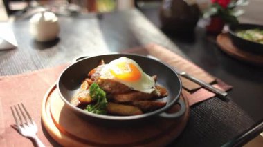 Patates ve kızarmış yumurta yiyor