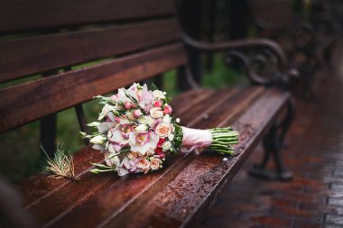 Buket ahşap bir Bank üzerinde yatıyor, arka plan bulanık yağmur