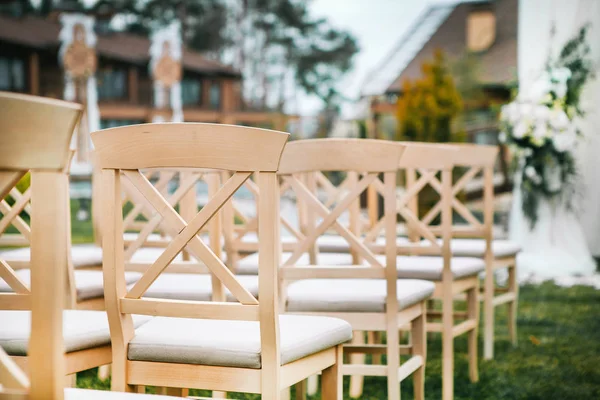 Een heleboel houten stoelen op de huwelijksceremonie — Stockfoto