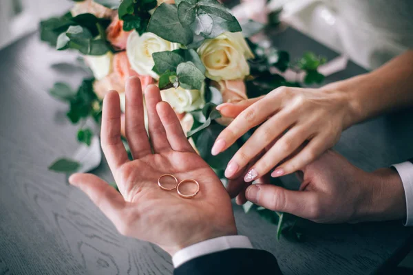 Anéis de casamento de ouro estão na mão da noiva — Fotografia de Stock