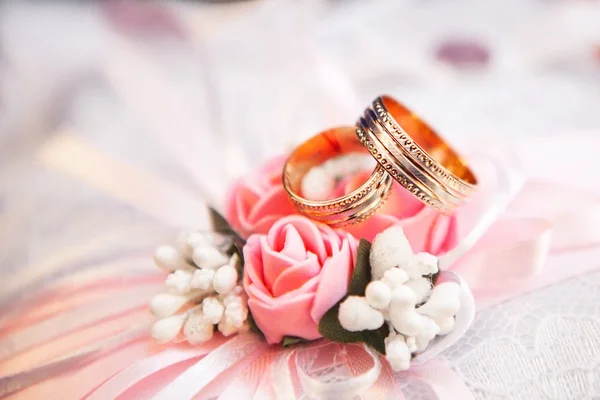 Χρυσά γαμήλια δαχτυλίδια βρίσκονται σε ένα κόκκινο μπουμπούκι — Φωτογραφία Αρχείου