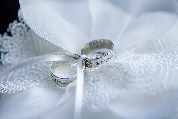 Anillos de plata de la boda se encuentran en la almohada —  Fotos de Stock