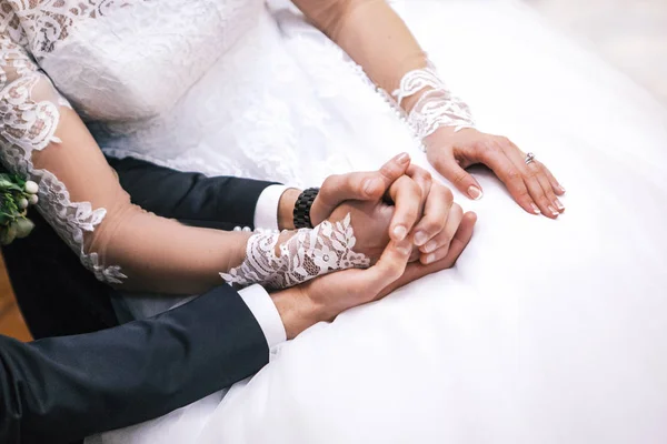 De bruidegom houdt de hand van de bruid vast — Stockfoto