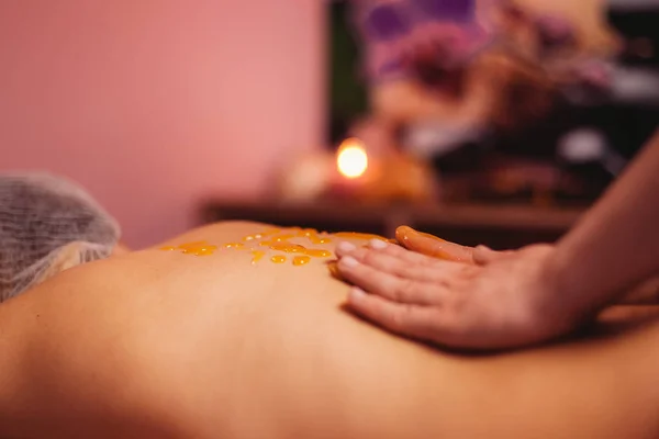 Vrouw massagetherapeut, met honing massage aan de achterzijde — Stockfoto