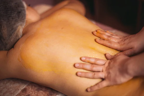 Masajista mujer, con masaje de miel en la espalda — Foto de Stock