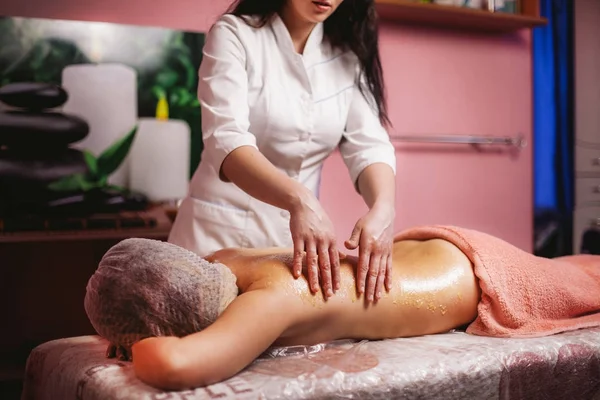Vrouw massagetherapeut, met honing massage aan de zijkanten — Stockfoto