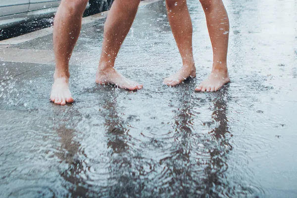 Fille et petit ami pieds nus sous la pluie — Photo