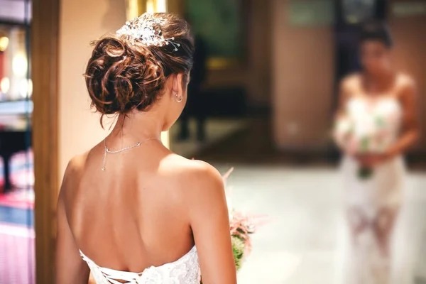 Bride with a beautiful hairdo in the mirror