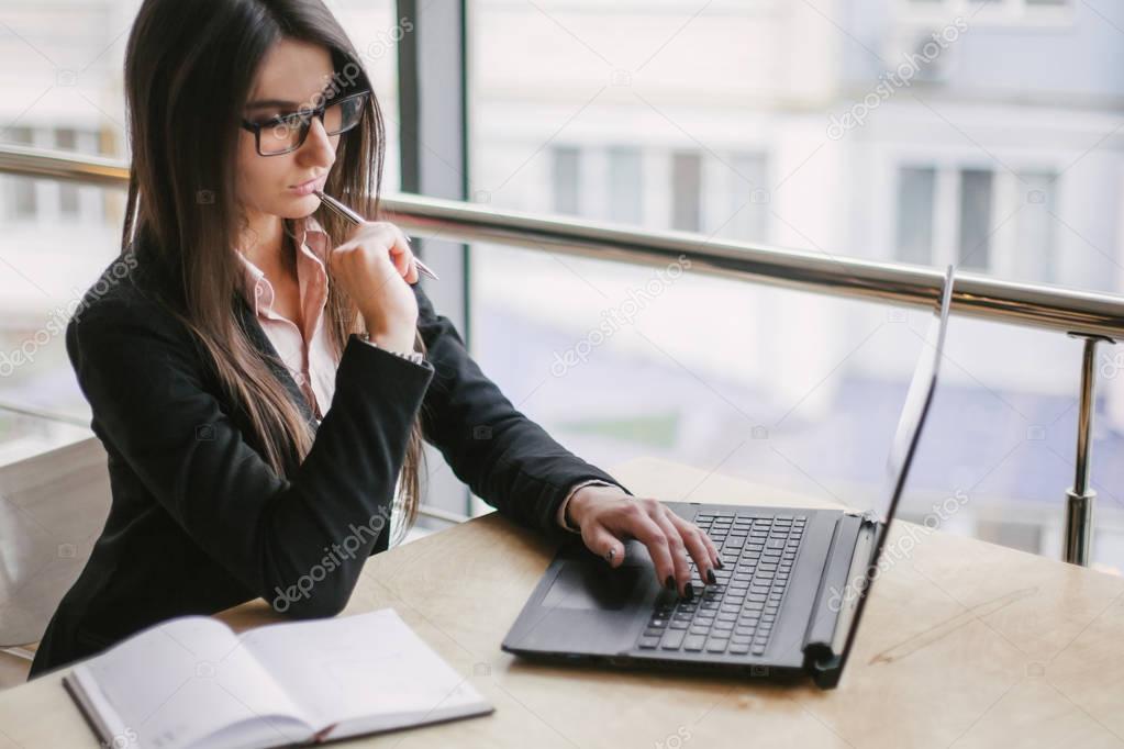 Business woman in the office sits on the left