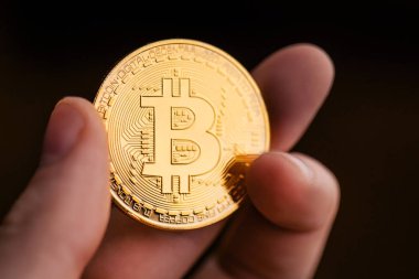 Altın parmak bitcoin ve siyah arka plan