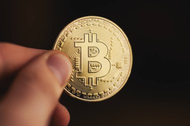 Altın bitcoin parmaklarını tutar