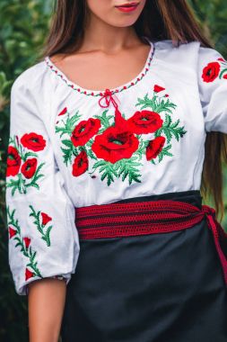 işlemeli beyaz bluz ile kemer haşhaş ve siyah etek kız duruyor