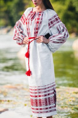 bir kırmızı etnik desen ve Kemer Bel, şık beyaz elbiseli kız duruyor
