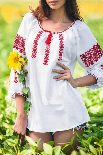 Mädchen Steht Bestickter Bluse Und Hält Eine Sonnenblume Der Hand — Stockfoto