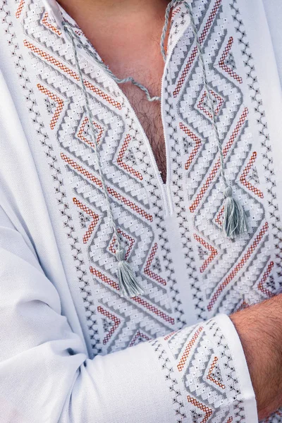 Homme Tient Chemise Brodée Blanche Avec Des Motifs Gris Rouges — Photo