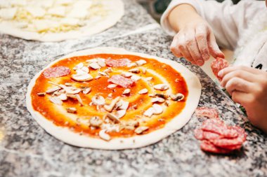 hamur mantar, peynir ve sosis lezzetli pizza için çocuk koyar