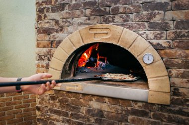 sıcak soba küreği ile pizza yemek koyar