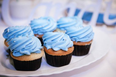 bir tepsi üzerinde mavi krem ve inci stand ile kek dekore