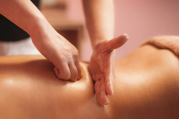 a masseur doing massage of back by hands