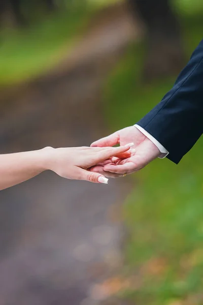 彼の手で女性の手を握って夏に公園で — ストック写真