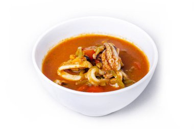 Beyaz arka planda bir tabakta ahtapot çorbası.