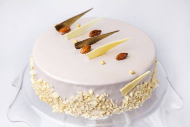 Beyaz bir tabakta beyaz pasta ve hafif çikolata.