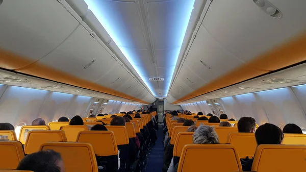 Aircraft cabin with passengers rear view