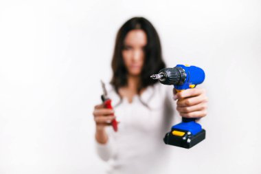 Beyaz arka planda mavi tornavidayı elinde tutan kız.