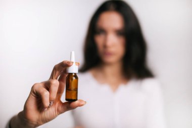 Kızın elinde burun damlası var.