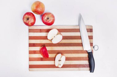 board with a knife and cut apples on a white background