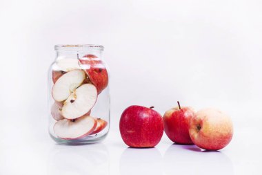 jar with apples stands on a white background