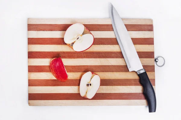 board with knife and chopped apples on a white background