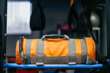 Sarı kum torbası spor salonunda yatıyor.