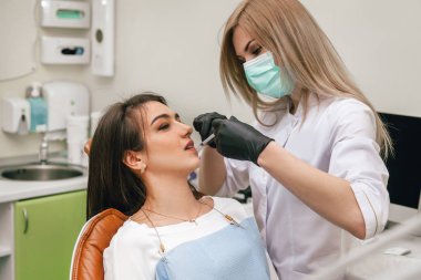 Doktor alt çeneye iğne yapar.