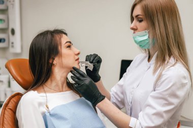 Doktor hastaya kürek kemiği takıyor.