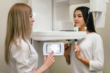 Dişçi kız dişlerin panoramik radyografisini yapıyor.