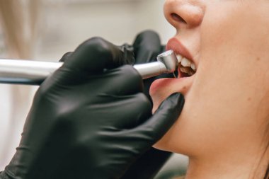 Dişçi ön dişçi kızı tedavi ediyor.