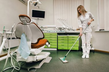 Dişçi ofisini ve iş yerini temizler.