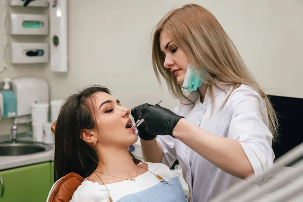 Dişçi doktor dikkatlice bir kıza enjekte eder.