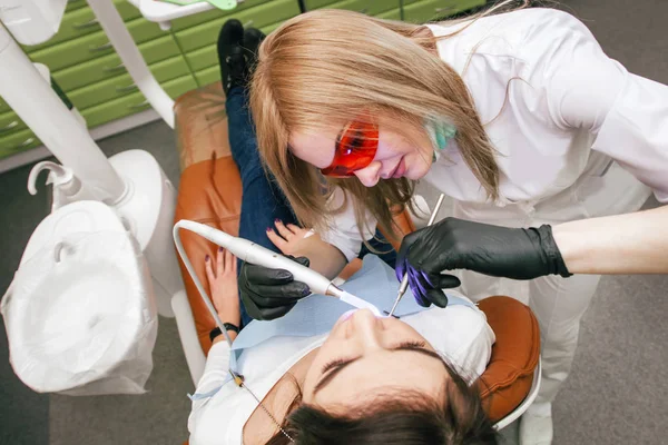 Dentista Dirige Luz Ultravioleta Sobre Paciente Consultorio — Foto de Stock