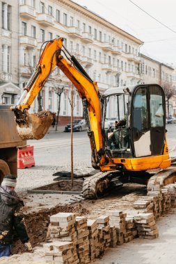Küçük sarı traktör karayı topluyor.