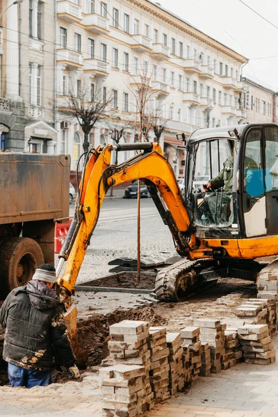 small yellow tractor loads the earth